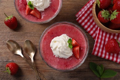 Photo of Delicious strawberry mousse with mint on wooden table, flat lay