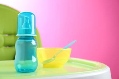 Photo of Set of plastic dishware on white feeding table. Serving baby food