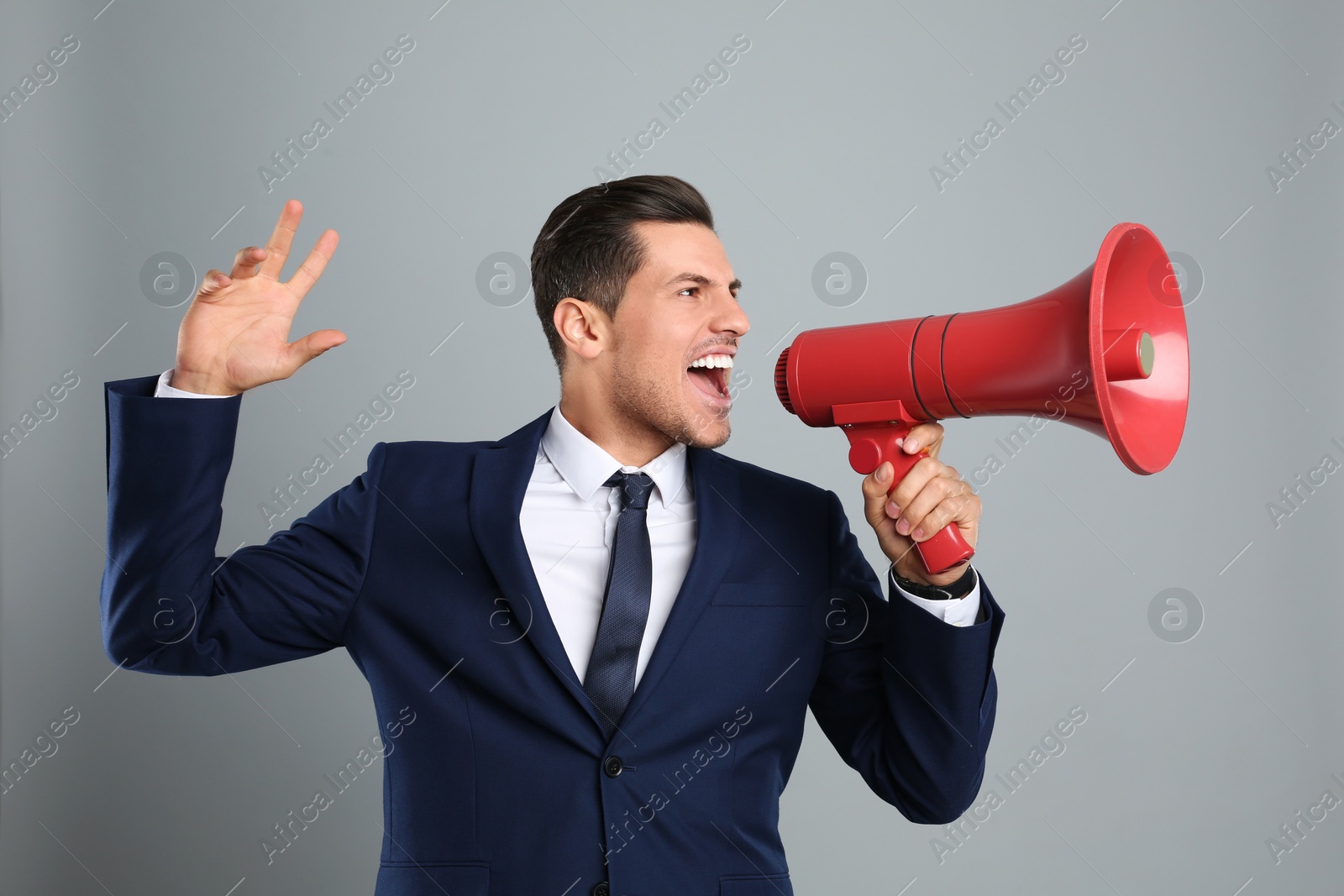 Photo of Handsome man with megaphone on grey background