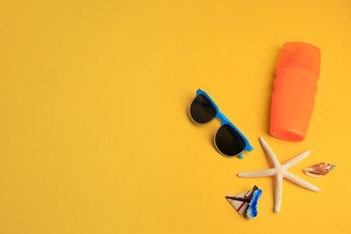 Flat lay composition with bottle of sunscreen on yellow background. Space for text