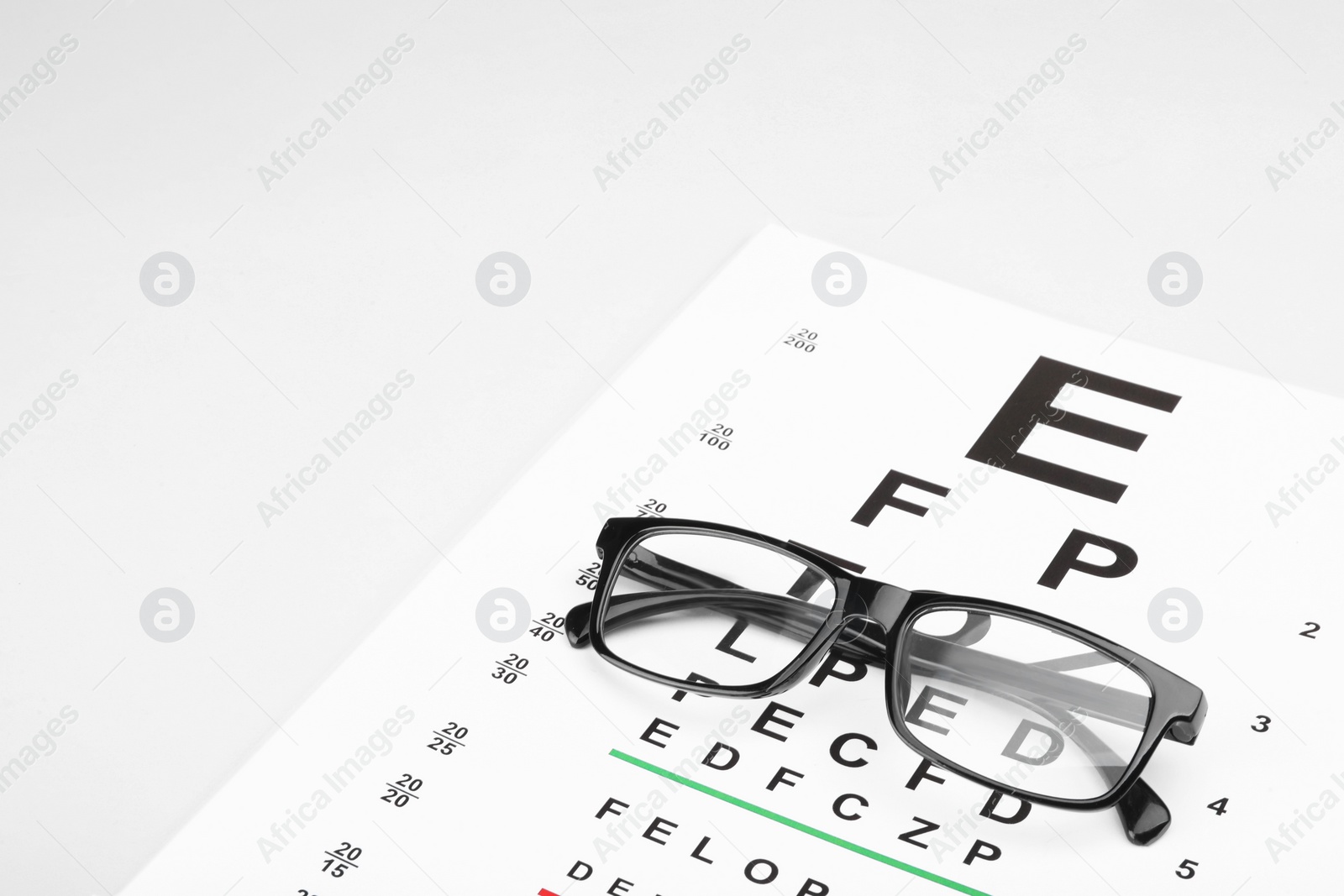 Photo of Glasses and vision test chart isolated on white