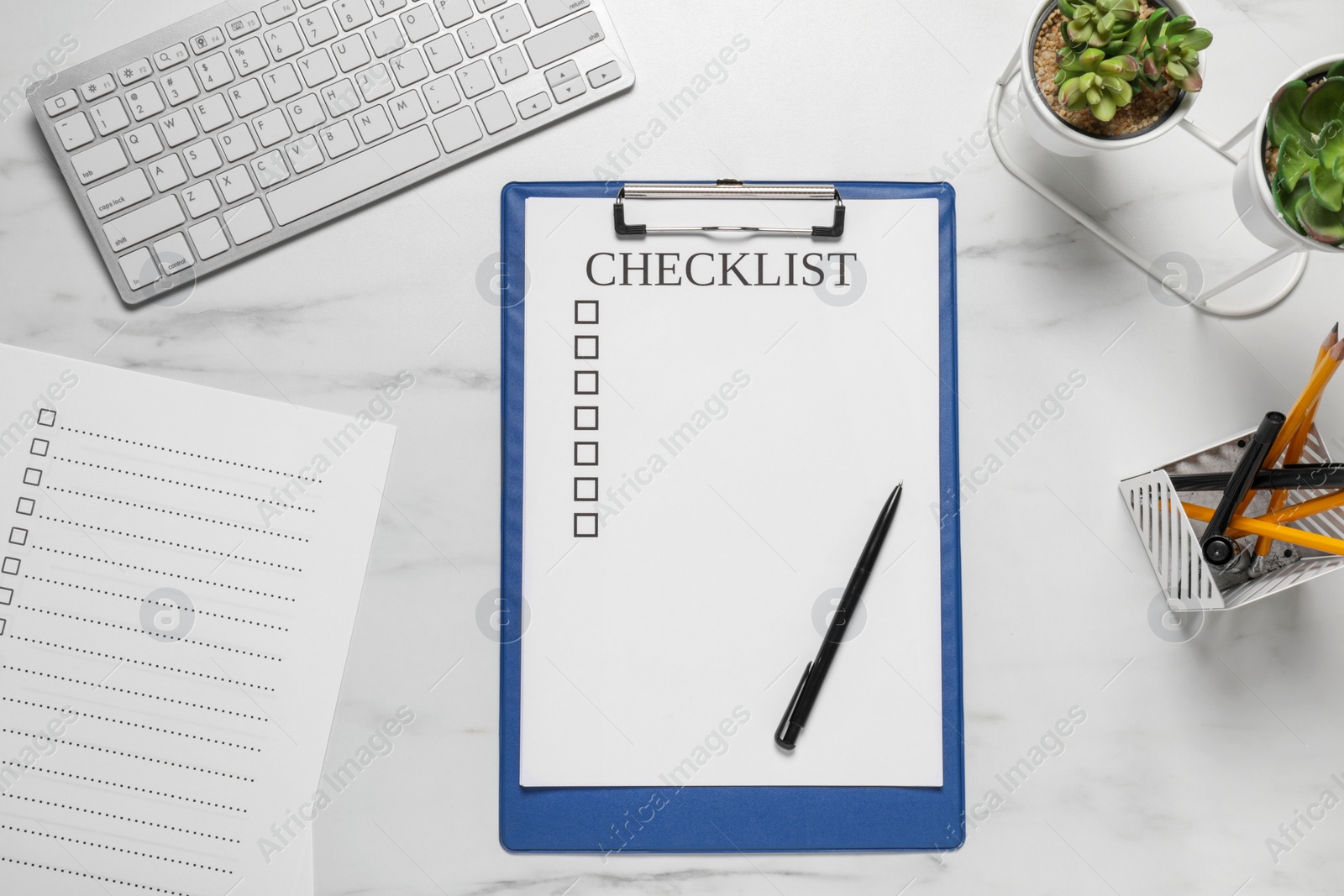 Photo of Clipboard with inscription Checklist, plants and computer keyboard on white marble table, flat lay