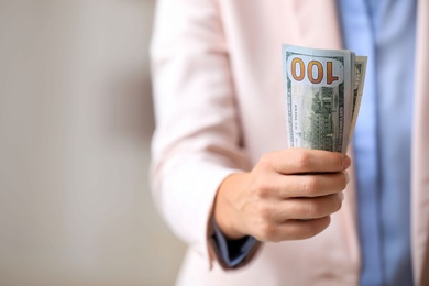 Woman with American money on light background, closeup