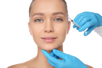 Young woman getting facial injection on white background. Cosmetic surgery concept