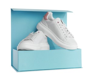 Pair of stylish sport shoes and turquoise box on white background