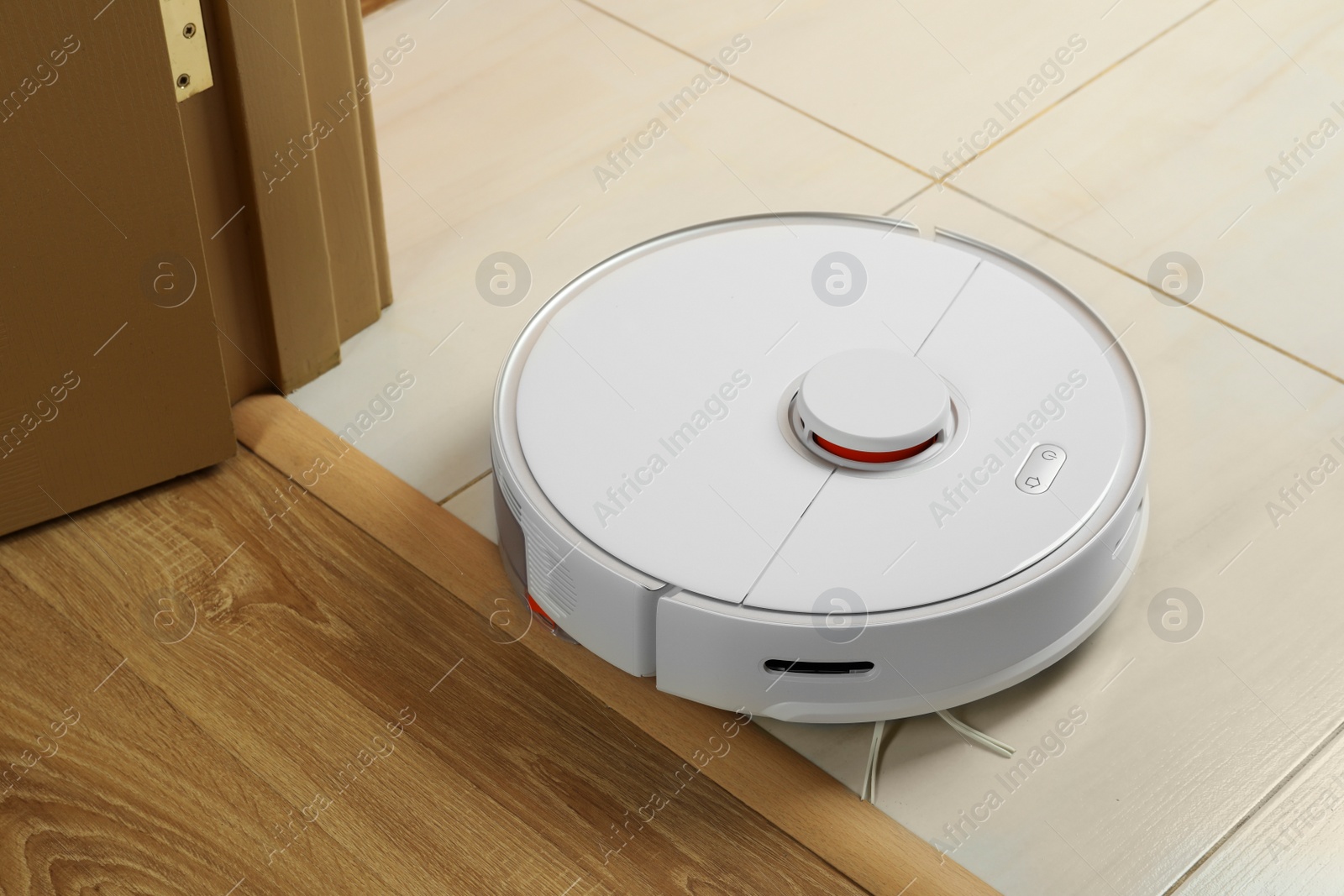 Photo of Modern robotic vacuum cleaner on white floor indoors