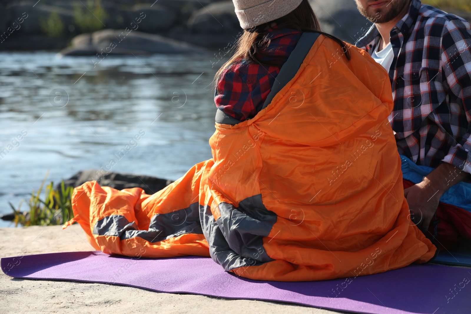 Photo of Campers in sleeping bags outdoors. Space for text