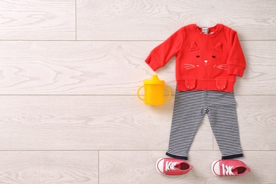 Set of baby clothes and accessories on wooden background, flat lay