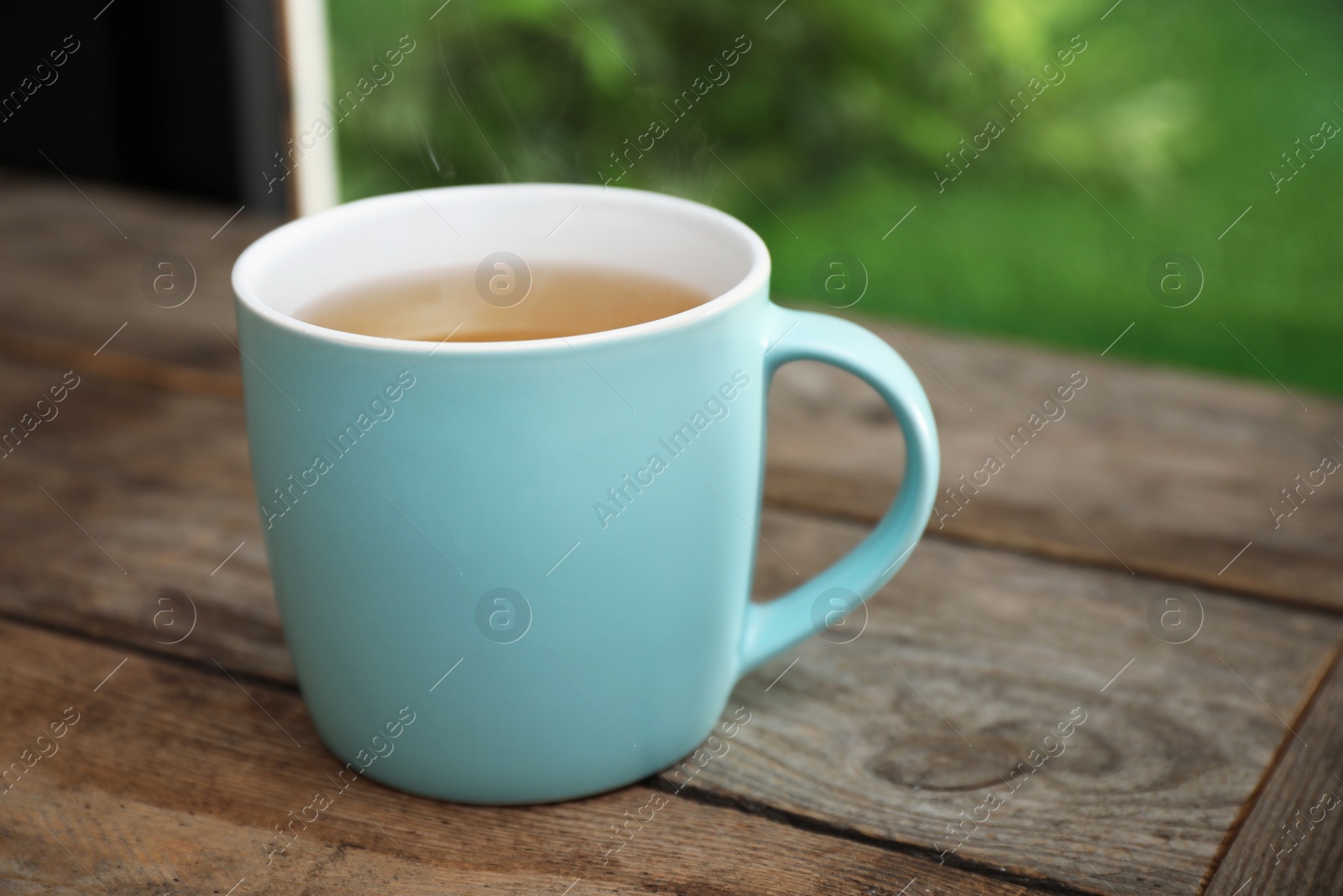 Photo of Cup of hot tea on wooden table