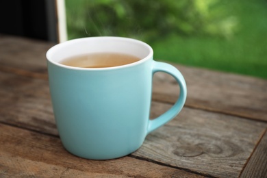 Photo of Cup of hot tea on wooden table