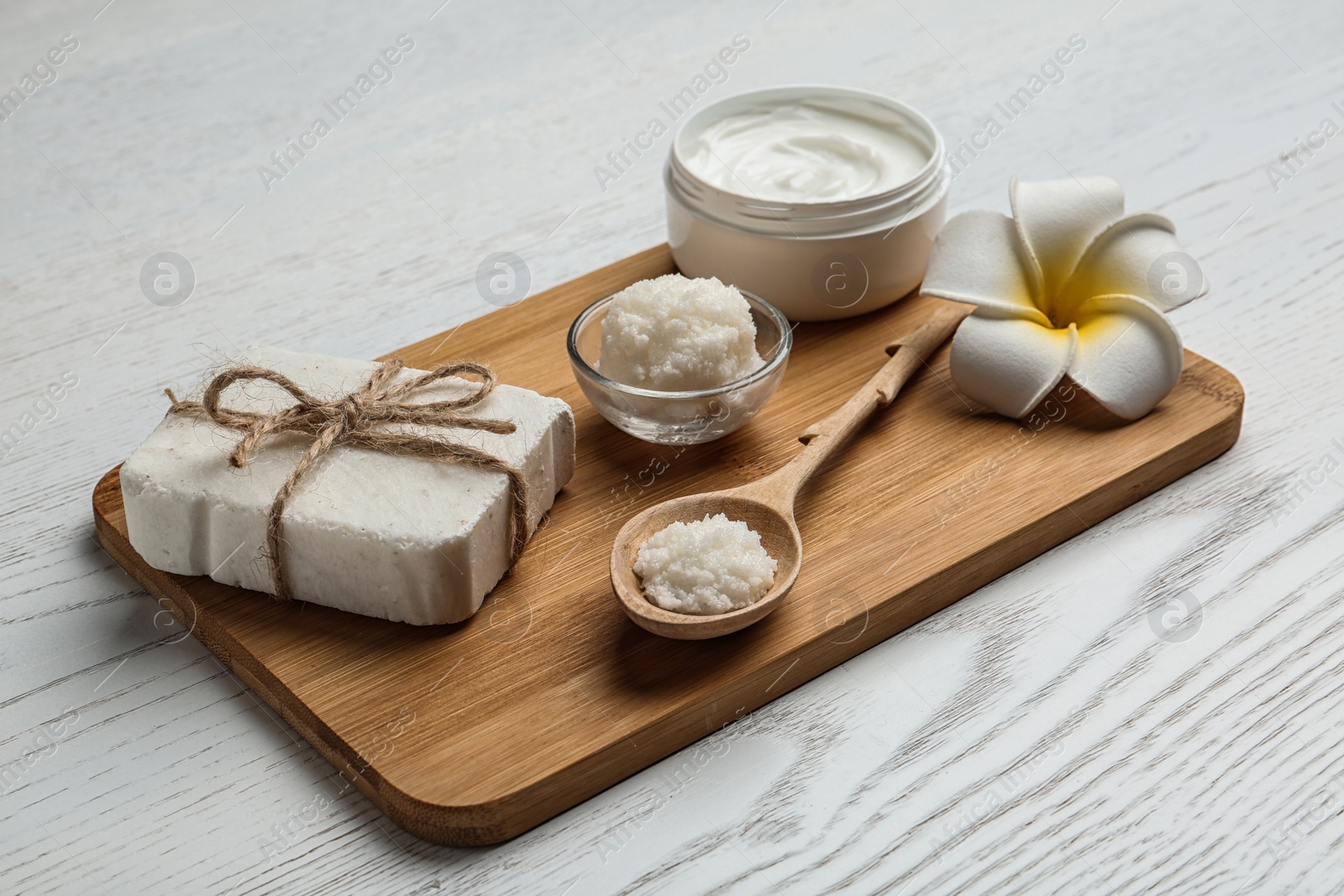 Photo of Board with Shea butter and cosmetic products on table