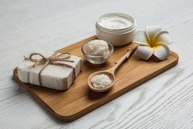 Board with Shea butter and cosmetic products on table