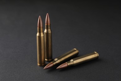 Photo of Many bullets on black background, closeup. Firearm ammunition