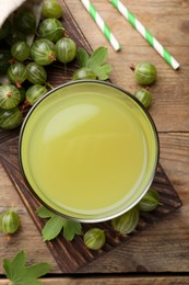 Tasty gooseberry juice and fresh berries on wooden table, flat lay