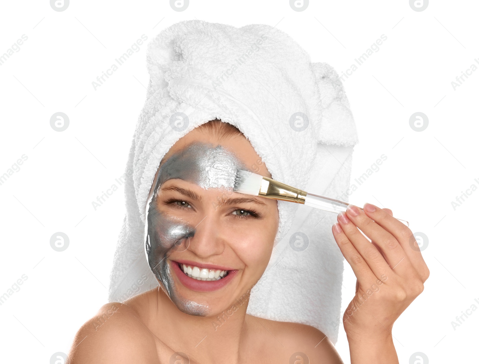 Photo of Beautiful woman applying silver mask on her face against white background