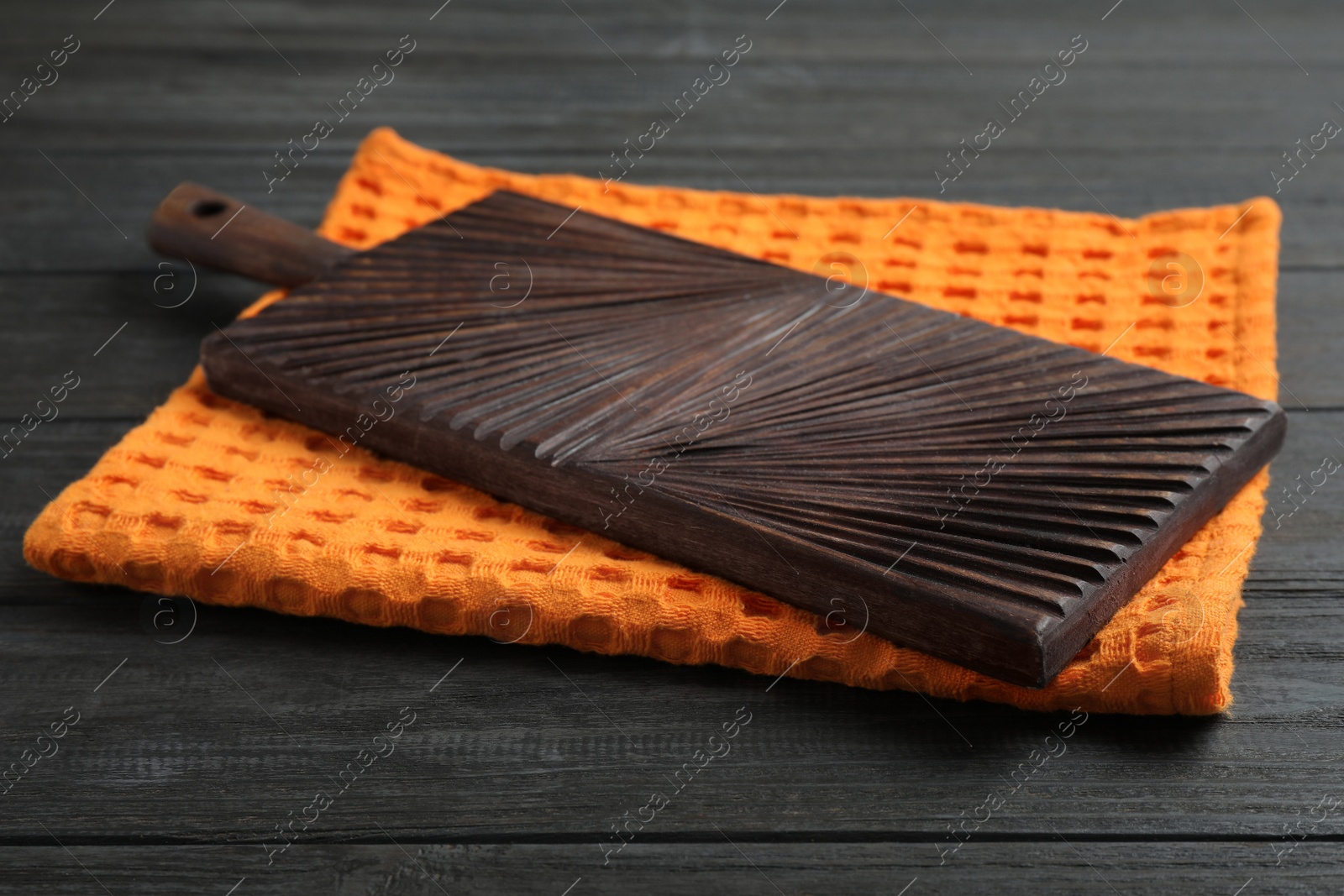 Photo of Kitchen towel and cutting board on black wooden table