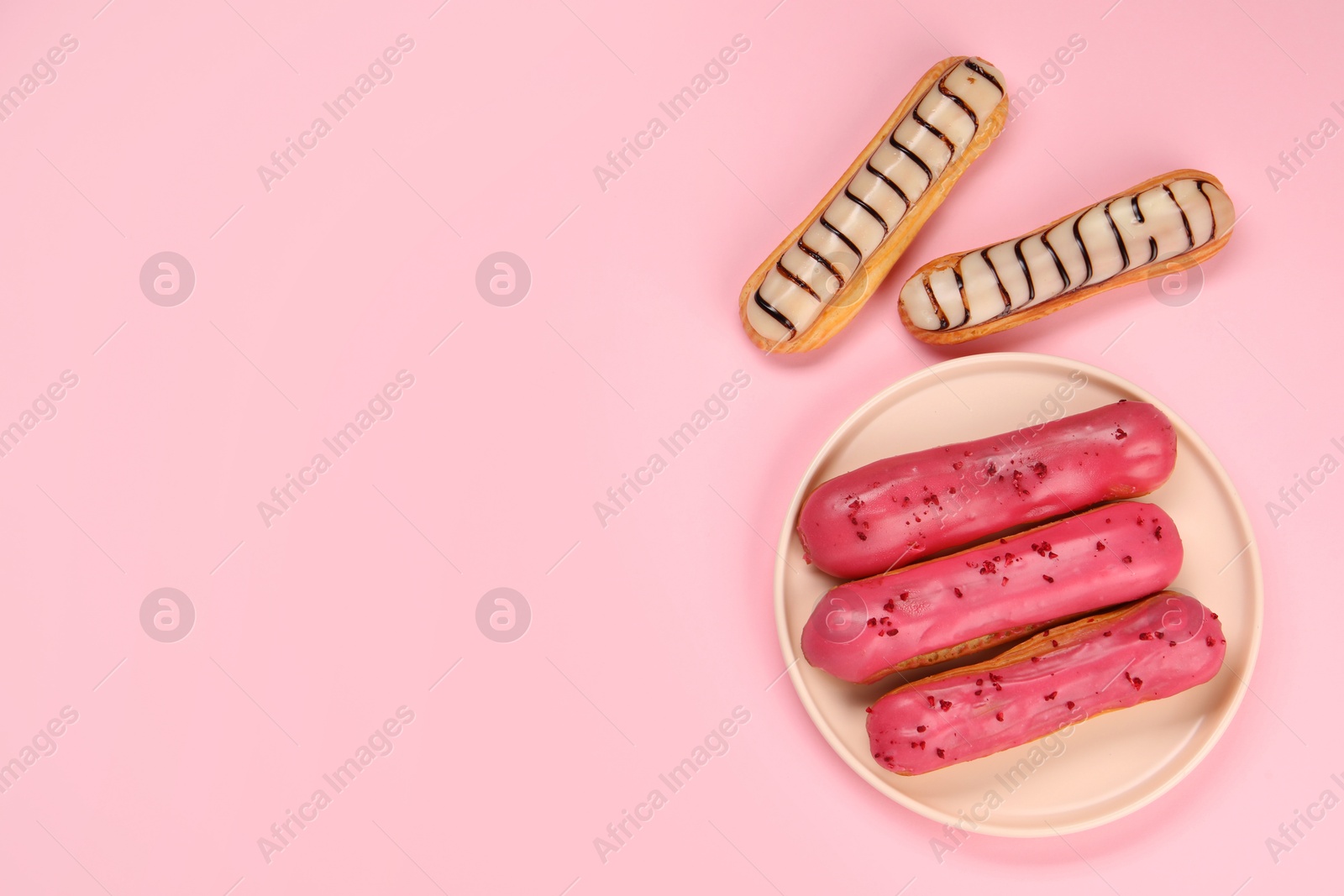 Photo of Delicious eclairs covered with glaze on pink background, flat lay. Space for text