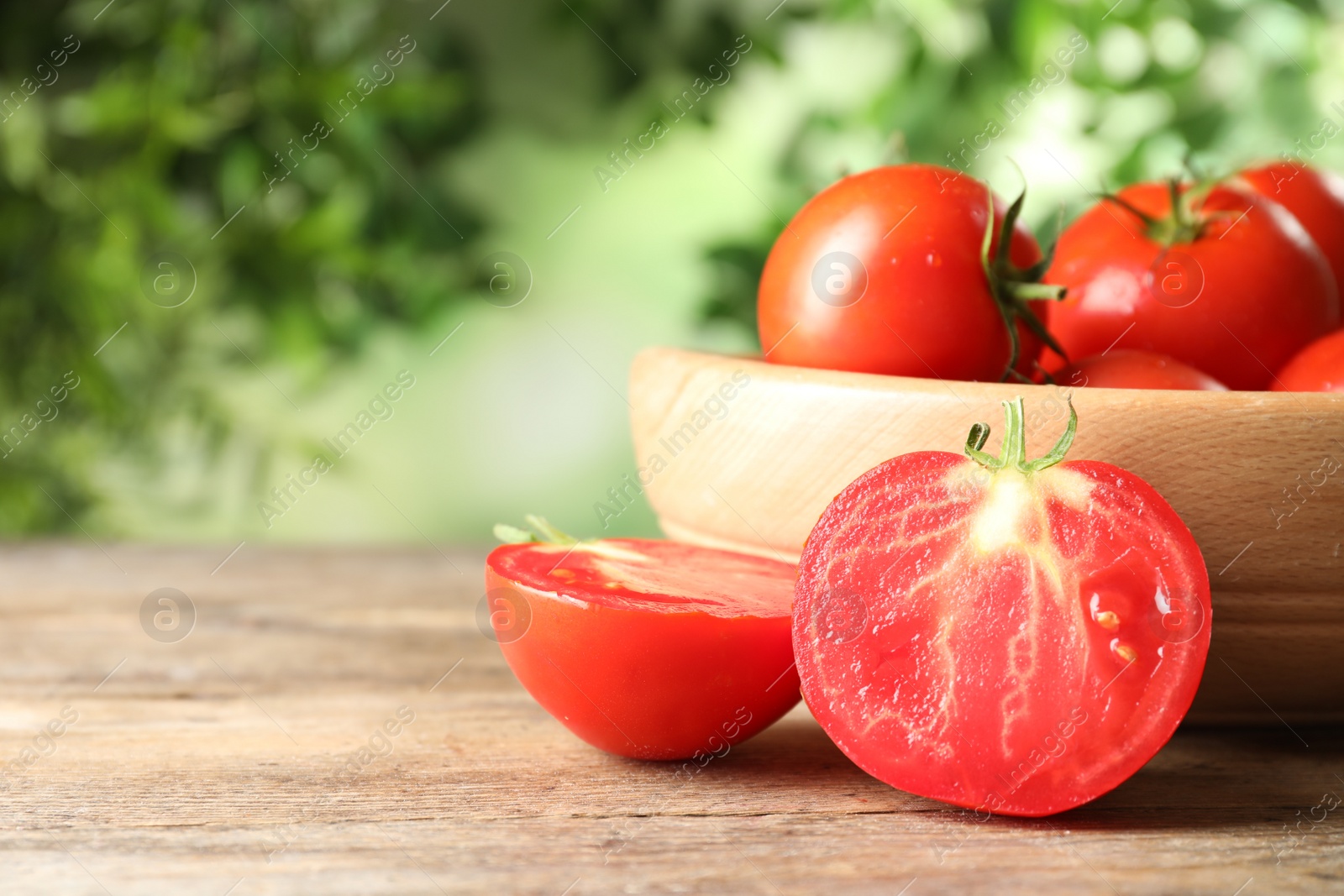 Photo of Fresh ripe tomatoes on wooden table. Space for text