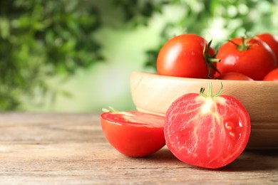 Photo of Fresh ripe tomatoes on wooden table. Space for text