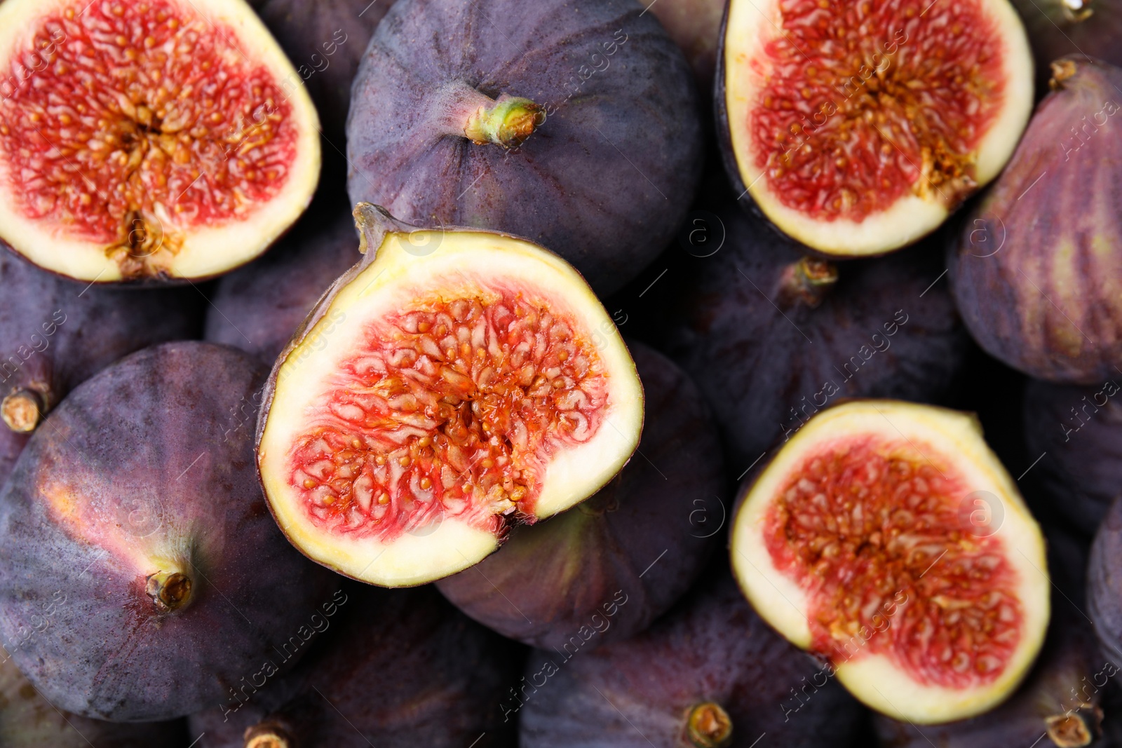 Photo of Cut and whole fresh ripe figs as background, top view