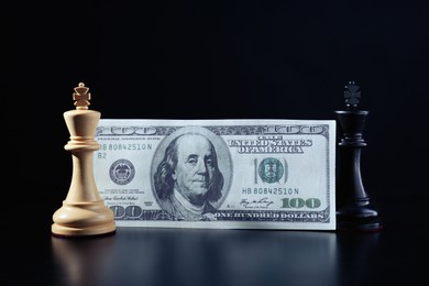 Money, white and black kings against dark background. Business competition concept