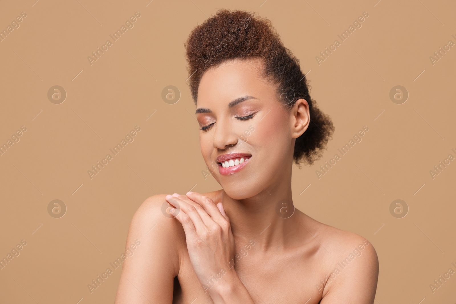 Photo of Portrait of beautiful young woman with glamorous makeup on light brown background