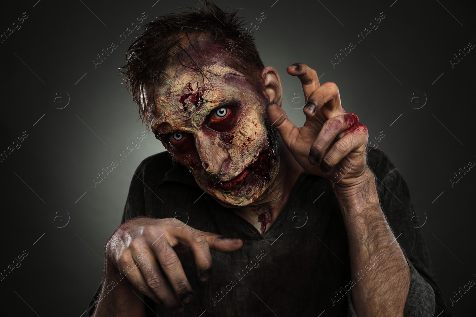 Photo of Scary zombie on dark background. Halloween monster