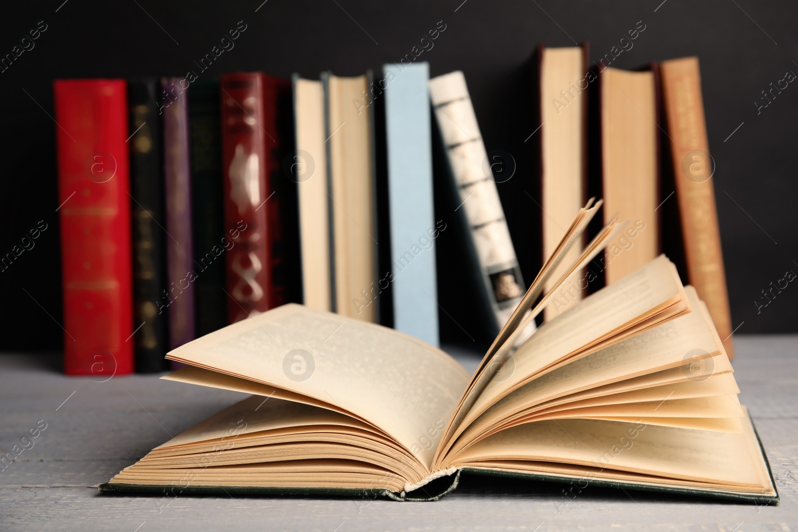 Photo of Open hardcover book on grey wooden table