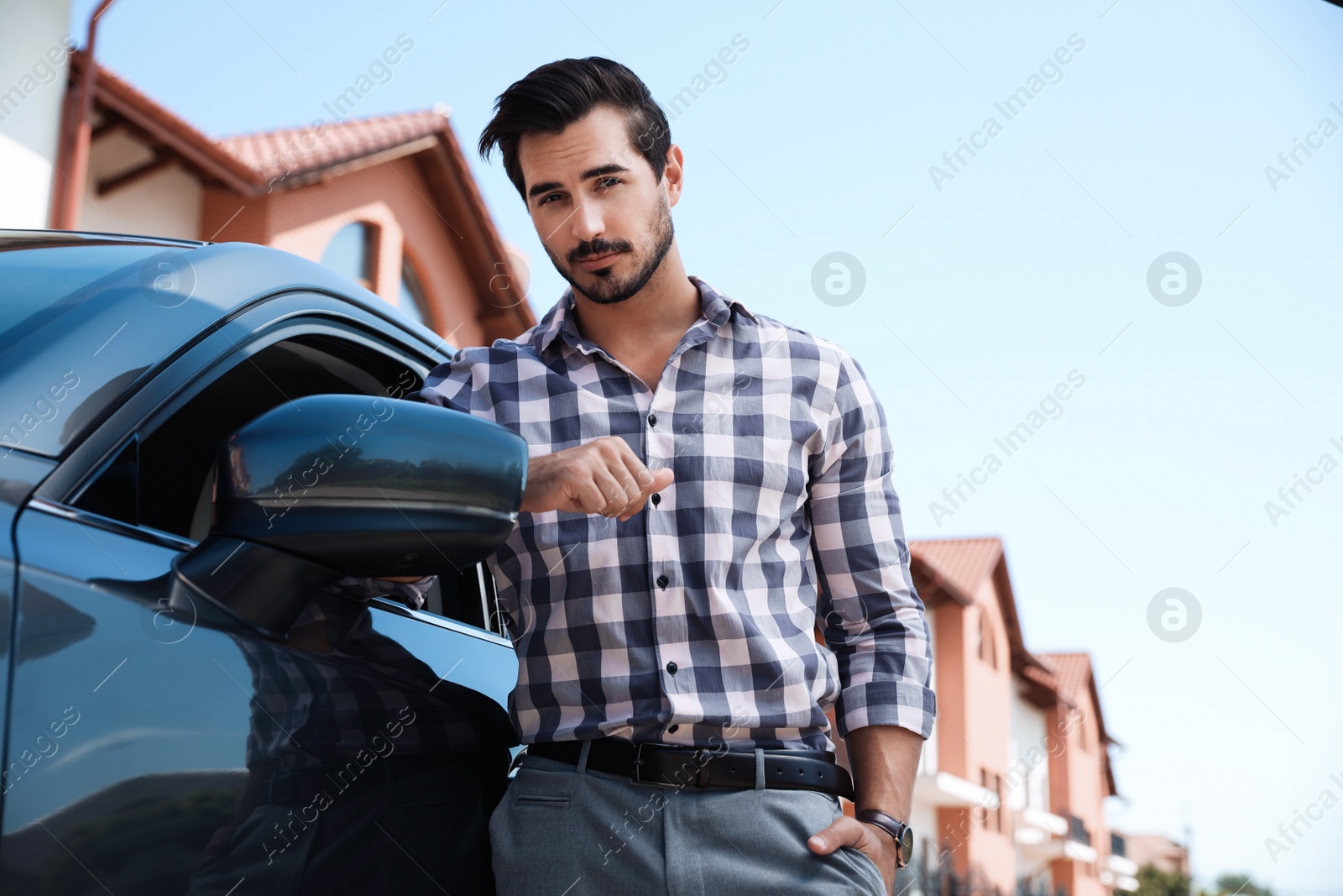 Photo of Attractive young man near luxury car outdoors