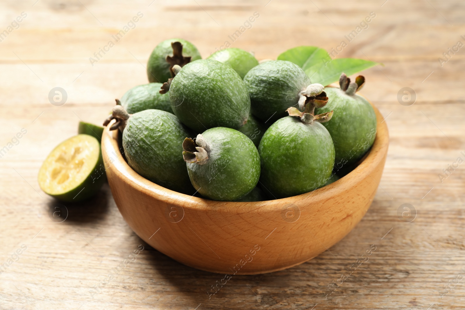 Photo of Fresh green feijoa fruits on wooden table, closeup