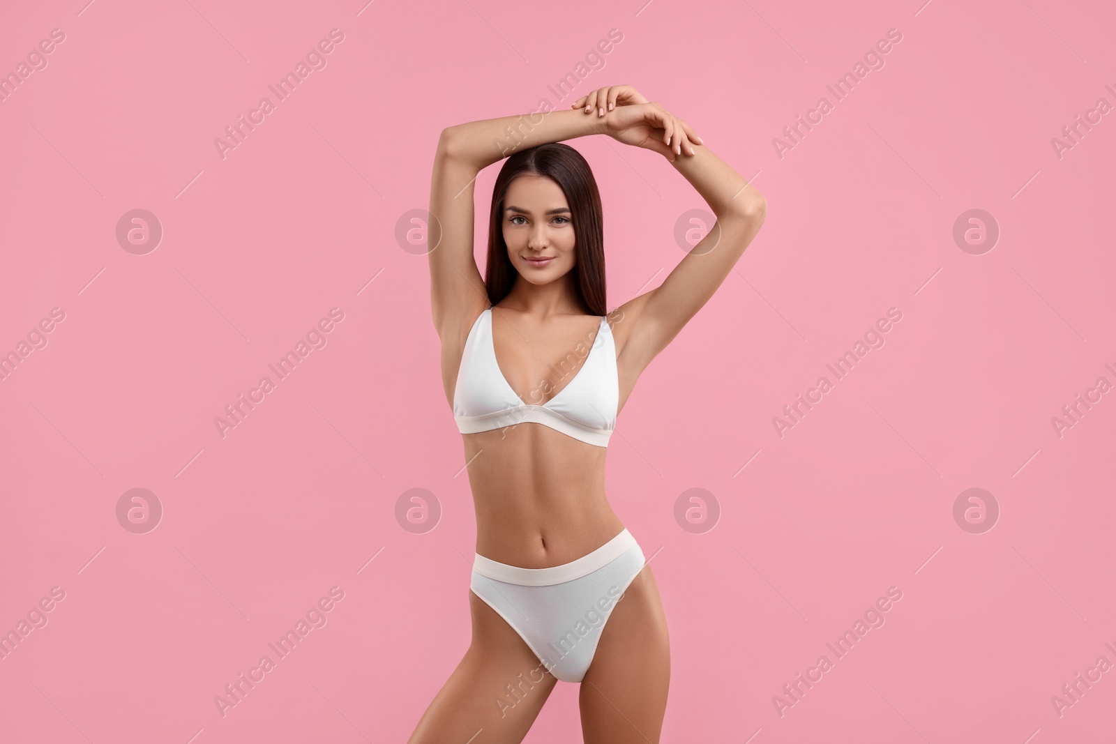 Photo of Young woman in stylish white bikini on pink background