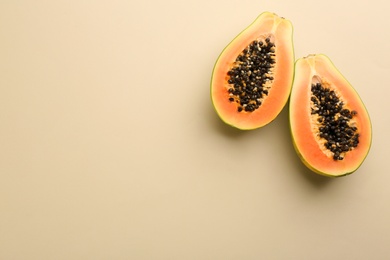 Photo of Fresh halved papaya fruit on beige background, flat lay. Space for text