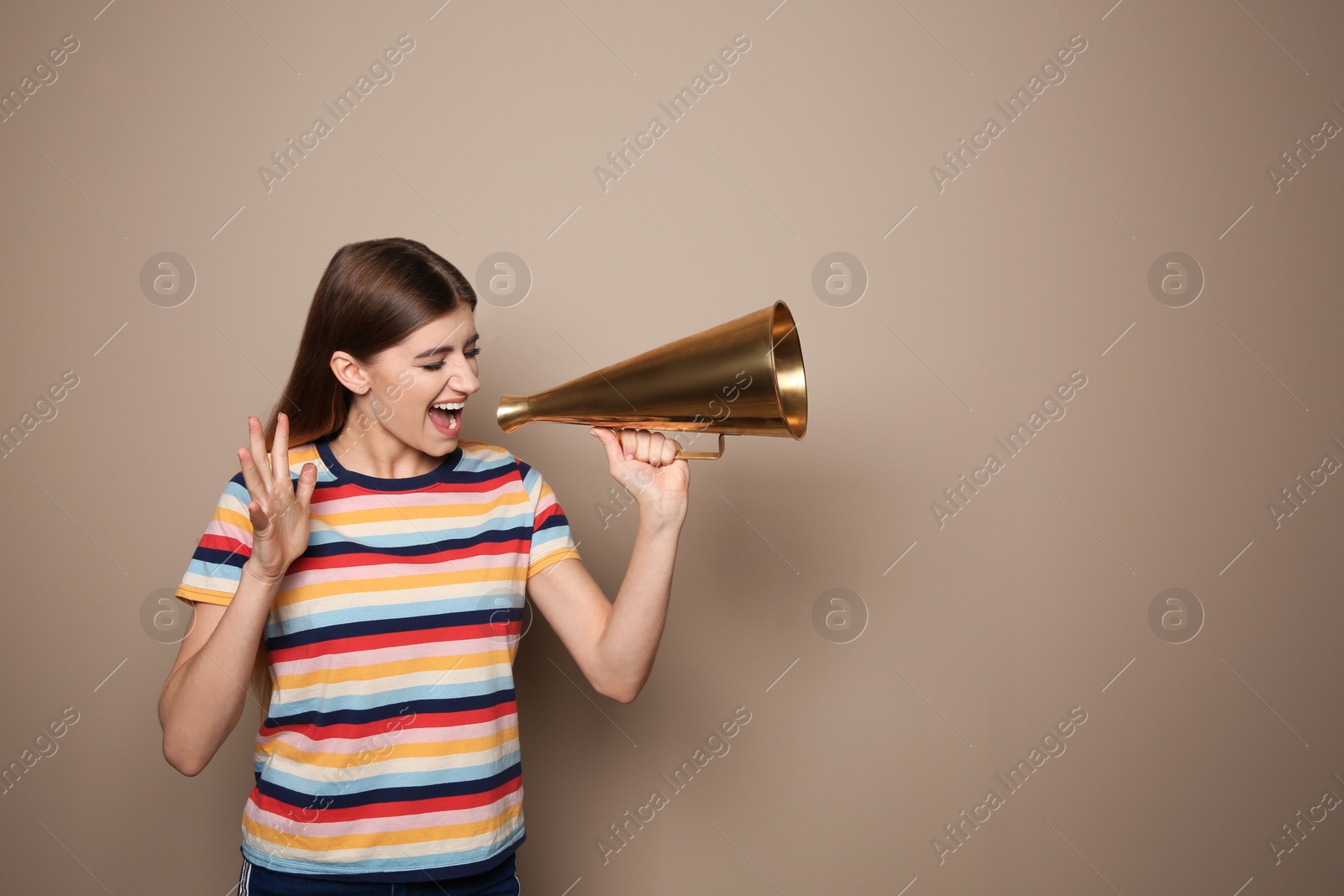 Photo of Young woman with megaphone on color background. Space for text