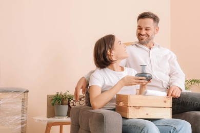 Photo of Happy couple unpacking box in new apartment. Moving day