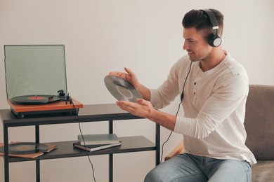 Happy man listening to music with turntable at home