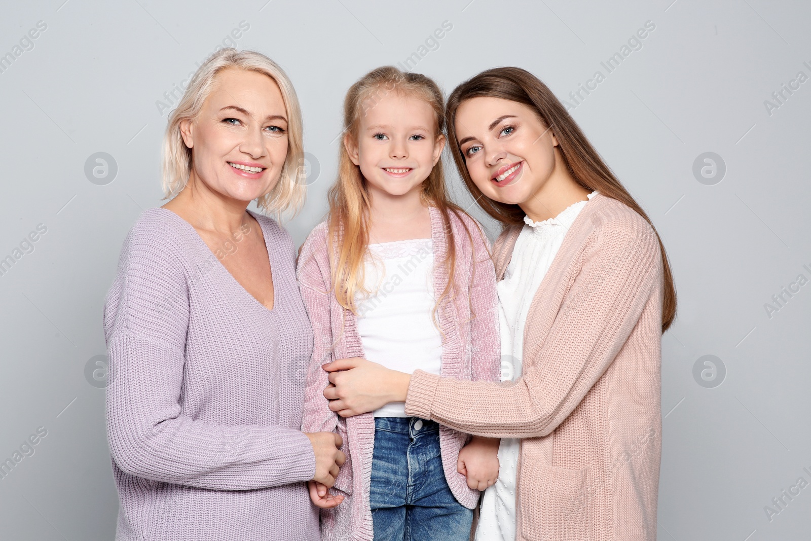 Photo of Portrait of young woman, her daughter and mature mother on color background