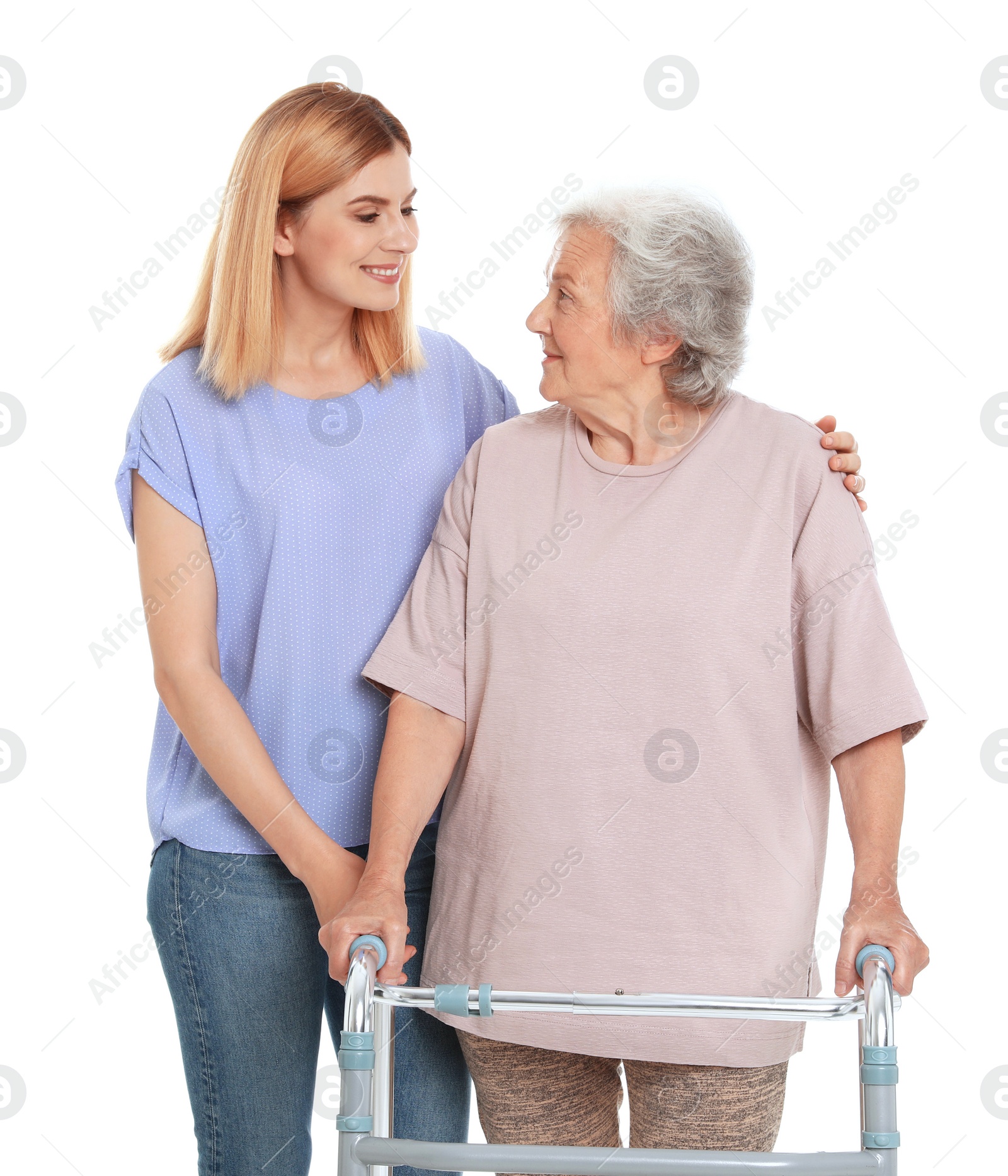 Photo of Caretaker helping elderly woman with walking frame on white background