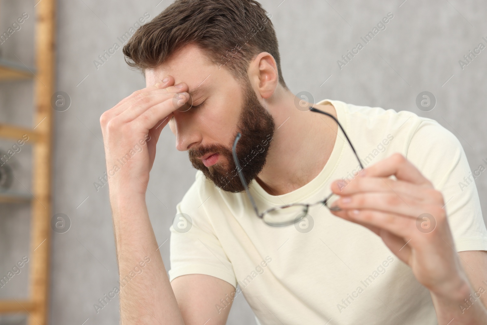 Photo of Overwhelmed man with glasses suffering at home