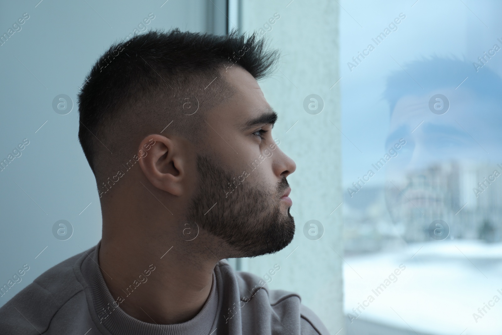 Photo of Sad man looking at window at home