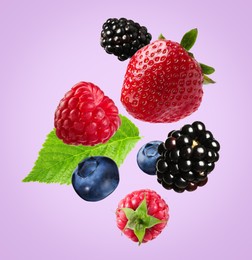 Image of Many different fresh berries falling on light violet background