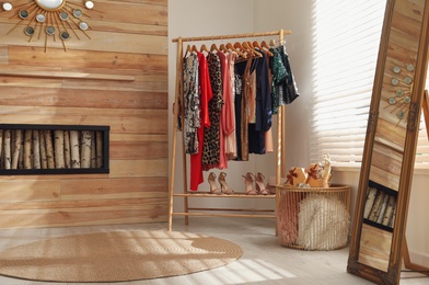 Rack with stylish women's clothes in room. Interior design