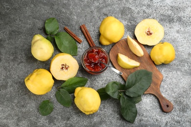 Delicious quince jam and fruits on grey table, flat lay