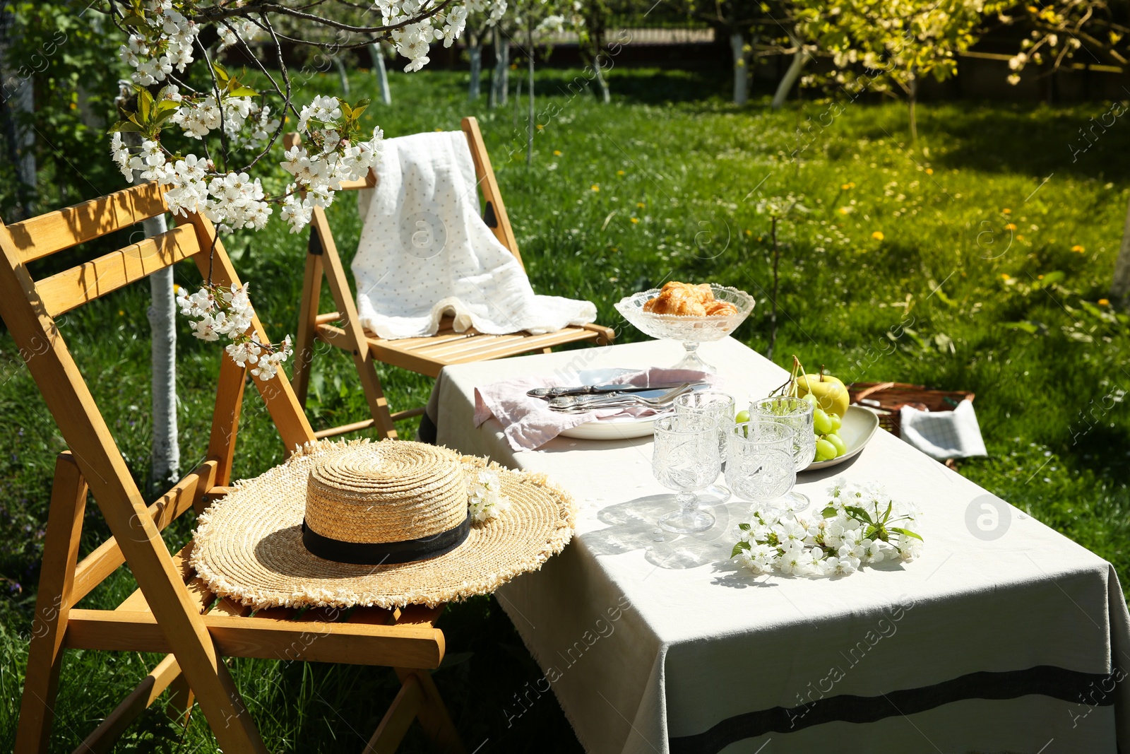 Photo of Stylish table setting with beautiful spring flowers in garden on sunny day