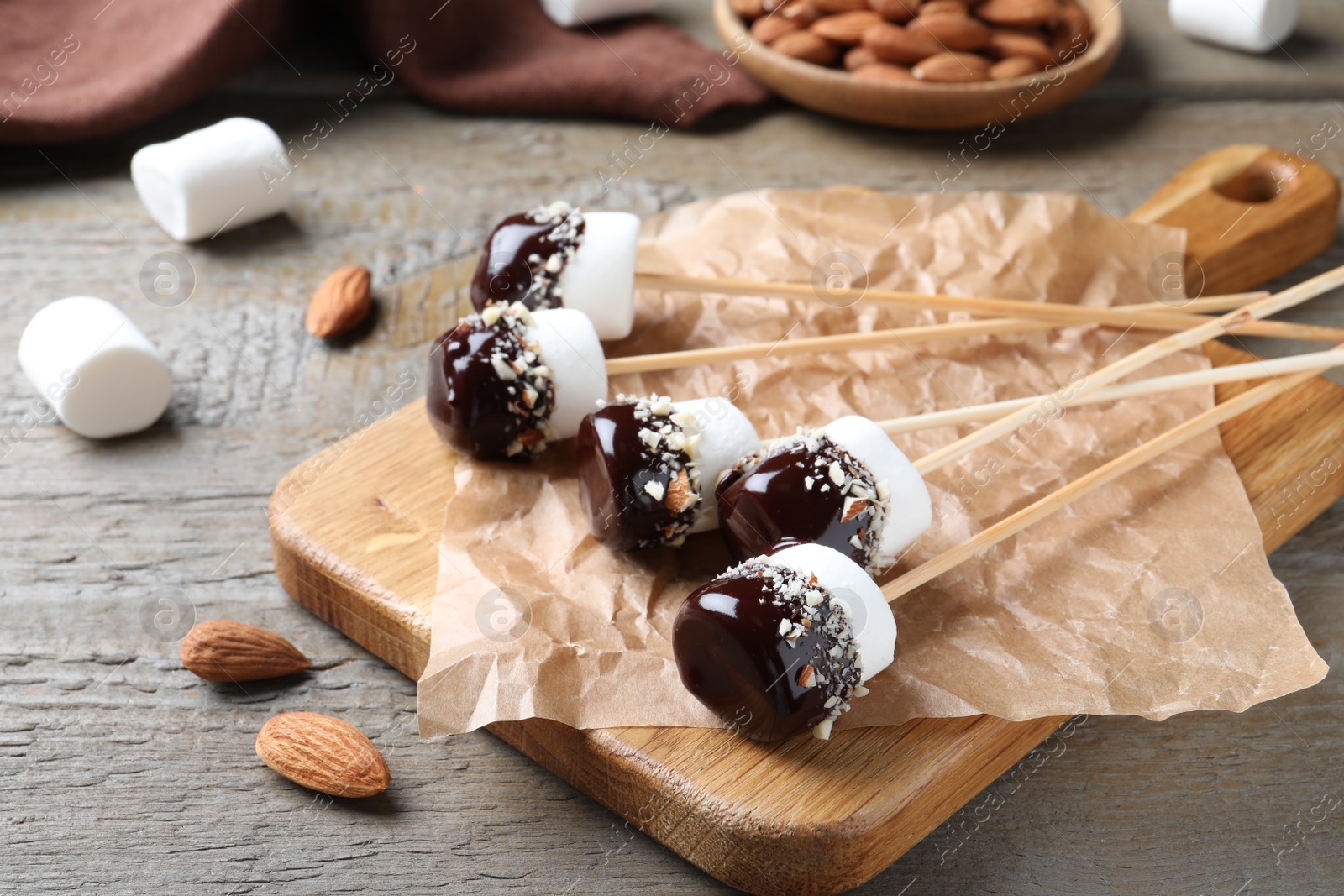 Photo of Delicious marshmallows covered with chocolate on wooden table