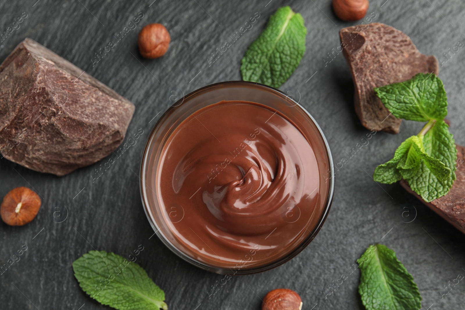 Photo of Flat lay composition with sweet chocolate mousse in glass on table