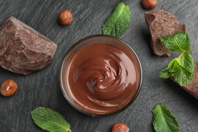 Photo of Flat lay composition with sweet chocolate mousse in glass on table