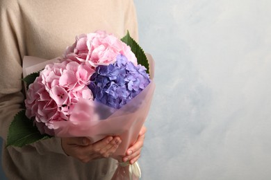 Photo of Woman with bouquet of beautiful hortensia flowers on color background, closeup. Space for text