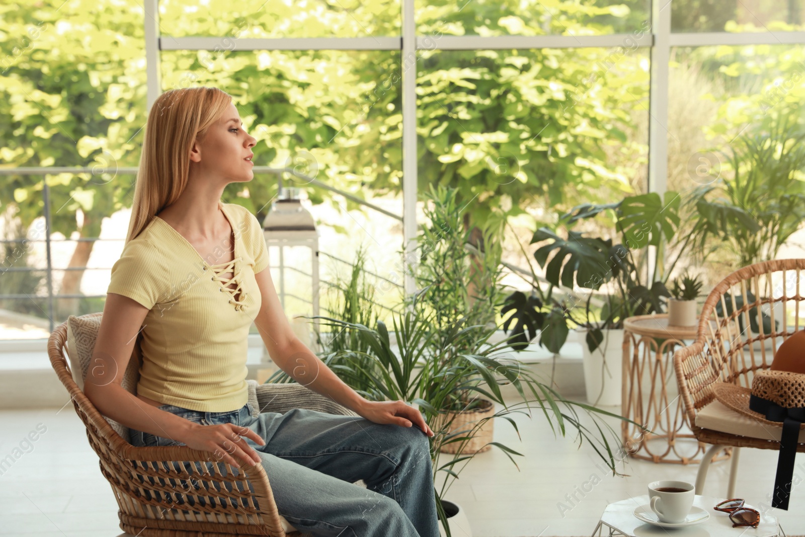 Photo of Young woman sitting in armchair at indoor terrace