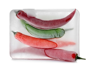 Photo of Chili peppers in ice cube on white background. Frozen vegetables