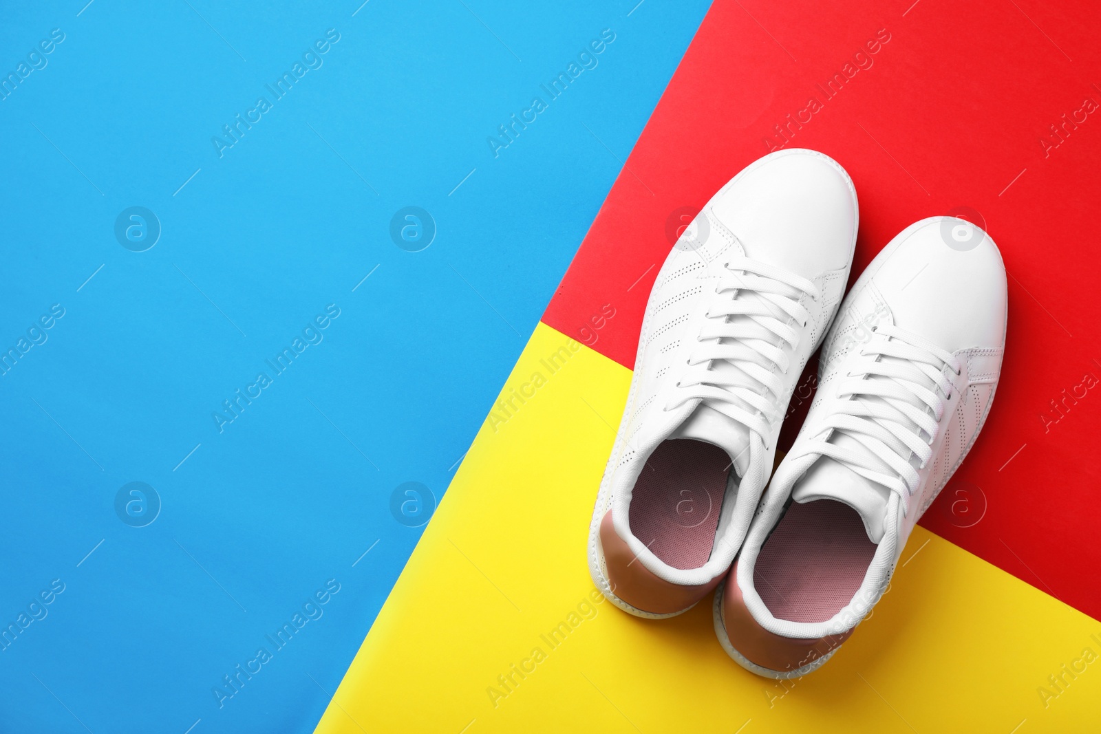 Photo of Pair of sneakers on color background, flat lay. Space for text